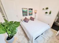 a bedroom with a bed with a potted plant at GregBnb-com - T2 Pleine Ville - CLIMATISE - BALCON - 1 in Toulon