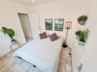 a bedroom with a white bed and some plants at GregBnb-com - T2 Pleine Ville - CLIMATISE - BALCON - 1 in Toulon