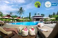 una piscina en un resort con mesas y sillas en Smile House - Fisherman Village, en Bophut 