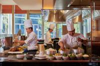 a group of chefs preparing food in a kitchen at Pavilion Hotel Kuala Lumpur Managed by Banyan Tree in Kuala Lumpur