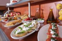 a table topped with plates of food and appetizers at Almira Hotel in Arkoudi