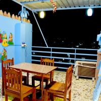 una mesa y sillas en una habitación con una pantalla grande en MH Guest House, en Jodhpur