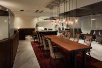 a dining room with a long wooden table and chairs at EN HOTEL Hakata in Fukuoka
