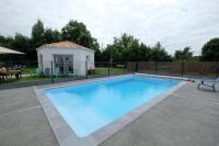 a swimming pool in a yard with a house at Au Logis des Mûriers in Vairé
