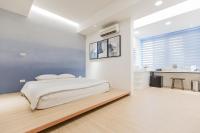 a white bedroom with a bed and a desk at Taitung Spring Homestay B&amp;B in Taitung City