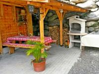a patio with a table and a bench and a grill at Ferienhaus Ematberg in Niedernsill