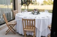 Una mesa blanca con vasos y un arreglo floral encima. en Conimbriga Hotel do Paço, en Condeixa a Nova