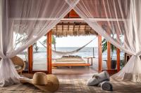 a bedroom with a hammock and a bed and the ocean at Kabana Hotel in Prea
