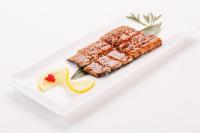 a white plate with a piece of sushi with a slice of lemon at Beijing Hotel Minsk in Minsk
