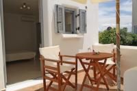 a wooden table and chairs on a balcony at Theofanis Studios in Agia Anna Naxos