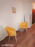 two chairs and a table in a room with a refrigerator at Superbe studio avec ascenseur à 50 mètres des cures et du centre ville in Vernet-les-Bains