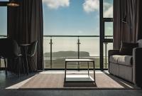 Una sala de estar con un sofá y una ventana grande. en Black Beach Suites, en Vík