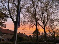 a sunset behind some trees in a residential neighborhood at Het Lichthuis in Zandvoort