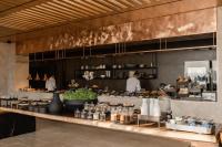 uma cozinha de restaurante com um balcão onde as pessoas preparam comida em Acro Suites - A Wellbeing Resort em Agia Pelagia