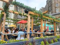a group of people sitting at tables in a garden at Kick Ass Greyfriars (18+) in Edinburgh