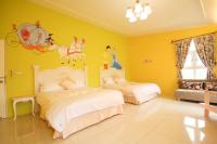 a bedroom with two beds and a yellow wall at Decoupage Manor in Jiaoxi