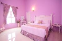a pink bedroom with a large bed in a room at Decoupage Manor in Jiaoxi