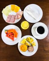 een tafel met borden eten en een kopje koffie bij Hotel Acalanto in Feira de Santana