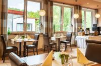 a restaurant with tables and chairs and windows at Hotel Rhön Residence in Dipperz