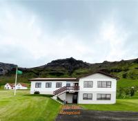 una casa blanca con una montaña al fondo en Litla-Hof Guesthouse, en Hof