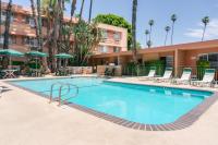 Una piscina con sillas y un edificio. en Saga Motor Hotel Pasadena, en Pasadena