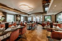 Un comedor con mesas y sillas y ventanas. en Alpine Hideaway ZILLERTALERHOF - 4 Sterne Superior, en Mayrhofen