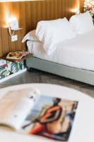 A bed or beds in a room at Collini Rooms Hotel
