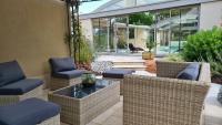 a patio with wicker chairs and a table at Maison de vacances Daumeray in Daumeray