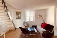 a living room with a couch and a staircase at **La Bretonnerie, bel appartement de standing in Concarneau