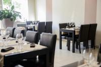 a dining room with tables and chairs with wine glasses at Logis Le Saint Hubert in Haybes