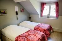 two beds in a small room with a window at Logis Le Saint Hubert in Haybes