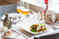 a table with a plate of food and glasses of beer at STF Långholmen Hostel in Stockholm