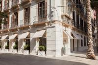 a white building with white awnings on a street at ICON Malabar in Málaga