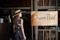 芭东海滩Holiday Inn Resort Phuket, an IHG Hotel的一位戴着帽子的女士站在标志牌旁边