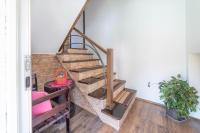 a wooden staircase in a living room with a plant at Apartments Vidik in Ivanjica