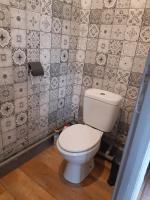 baño con aseo y pared de azulejos en MAISON Studio SEDAN Meublé 14M2 INDEPENDANT, en Sedan