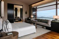 a bedroom with a large white bed and a couch at Capella Singapore in Singapore