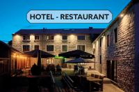a hotel restaurant with tables and umbrellas in front of a building at Hotel &amp; Restaurant Maison Pal&#39;Ange in Durbuy