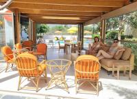 two women sitting on a couch on a patio with chairs at Arhodiko Hotel in Amoudara Herakliou