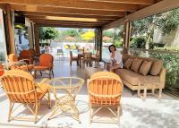 a woman sitting on a couch on a patio at Arhodiko Hotel in Amoudara Herakliou