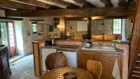 a kitchen with a sink and a counter with chairs at Gite du moulin in Pranzac
