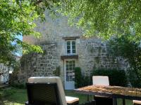 a stone building with a table with a laptop on it at Gite du moulin in Pranzac