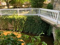 a bridge over a pond with a white fence at Gite du moulin in Pranzac