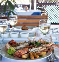 a plate of seafood on a table with glasses of wine at Hotel Club Dongwe in Pingwe