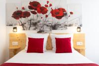 a bedroom with red pillows and red poppies on the wall at hotel le beauséjour in Langogne