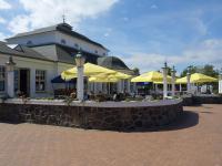 un bâtiment avec des tables et des parasols jaunes dans l'établissement FEWO "Hafenblick", à Ueckermünde