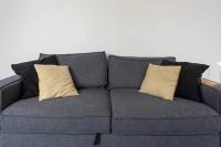 a gray couch with two yellow pillows on it at Appartement De Lerme in Bordeaux