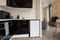 a kitchen with black cabinets and a white refrigerator at Appartement De Lerme in Bordeaux