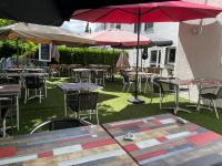 オルヴォーにあるHôtel AKENA Nantes Orvault - Ouestのテーブル、椅子、パラソルのある屋外パティオ