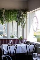 a table in a restaurant with chairs and a window at Haddington House in Dun Laoghaire